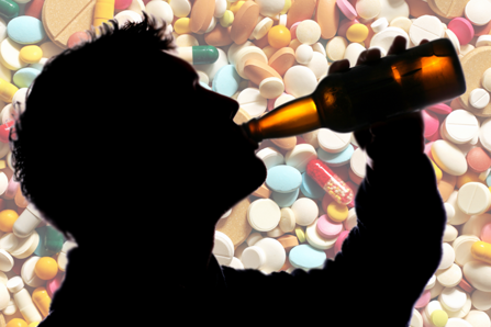 Drinking man silhouette against background of pills