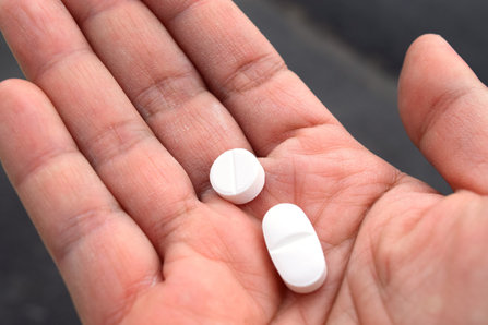 opioid pills in persons hand