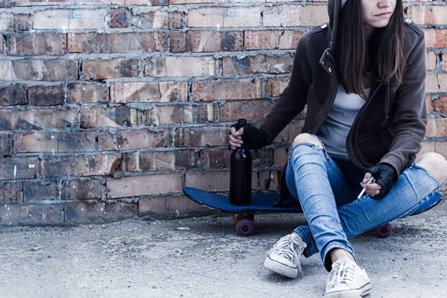 Girl with on a skateboard with an alcohol