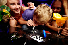 group of young adults at party using cocaine