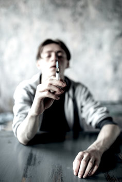 Guy sitting with syringe 