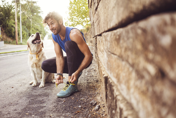Healthy young sober man in recovery exercising with a dog